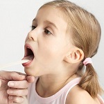 Девочке осматривают горло