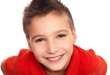Мальчик в красной майке улыбается