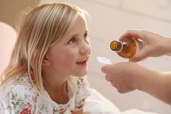 Девочке дают выпить лекарство