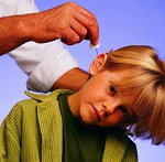 Мальчику капают капли в ухо