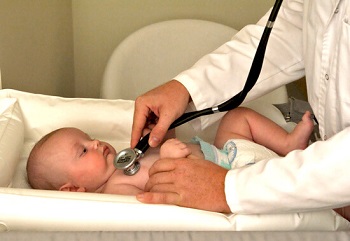 Маленького ребенка осматривает врач