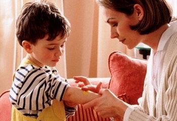 Мальчику наносят крем на руку